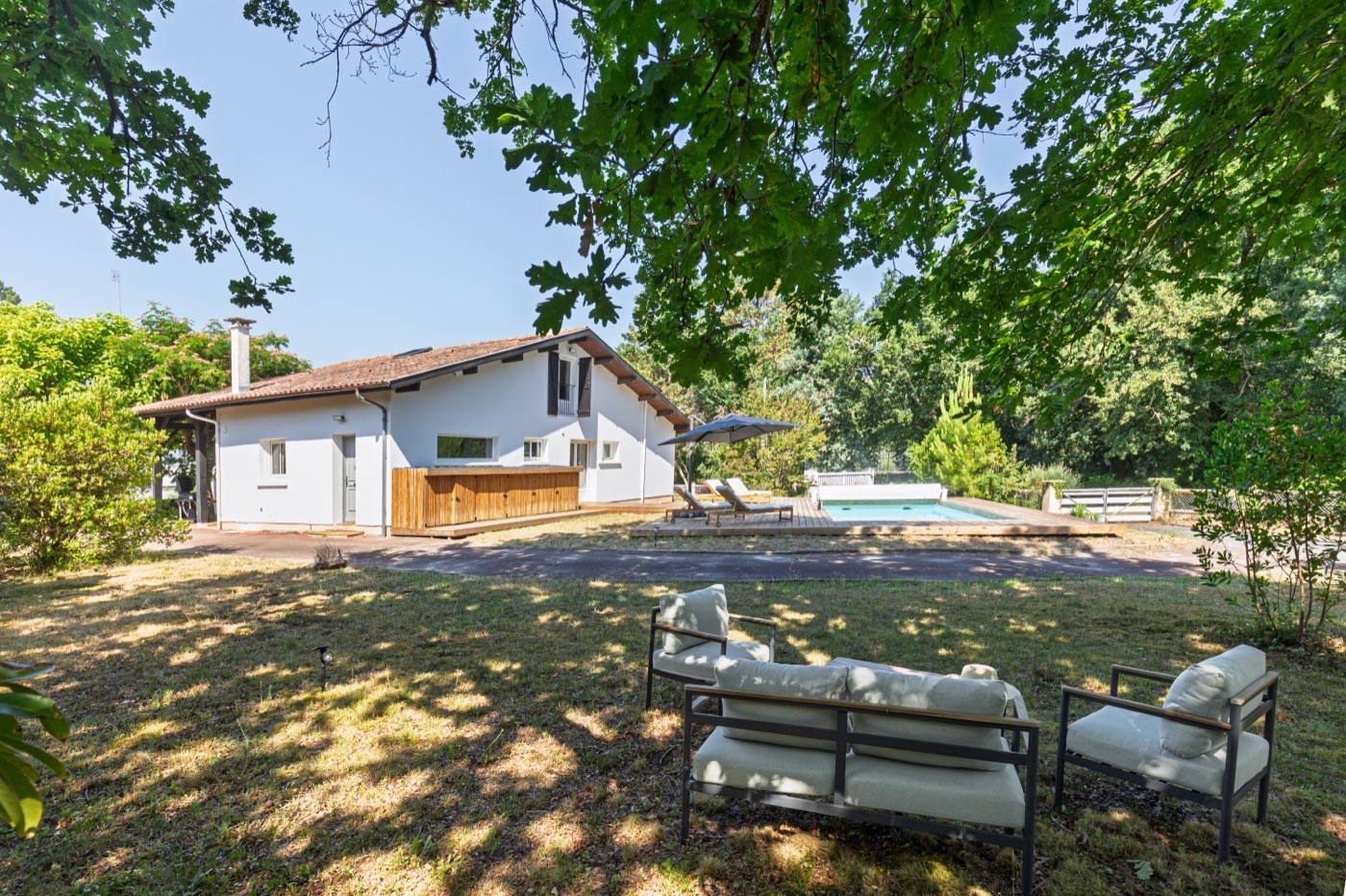 La villa vue du jardin, à l’ombre des chênes